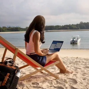A lady working on mac on beach